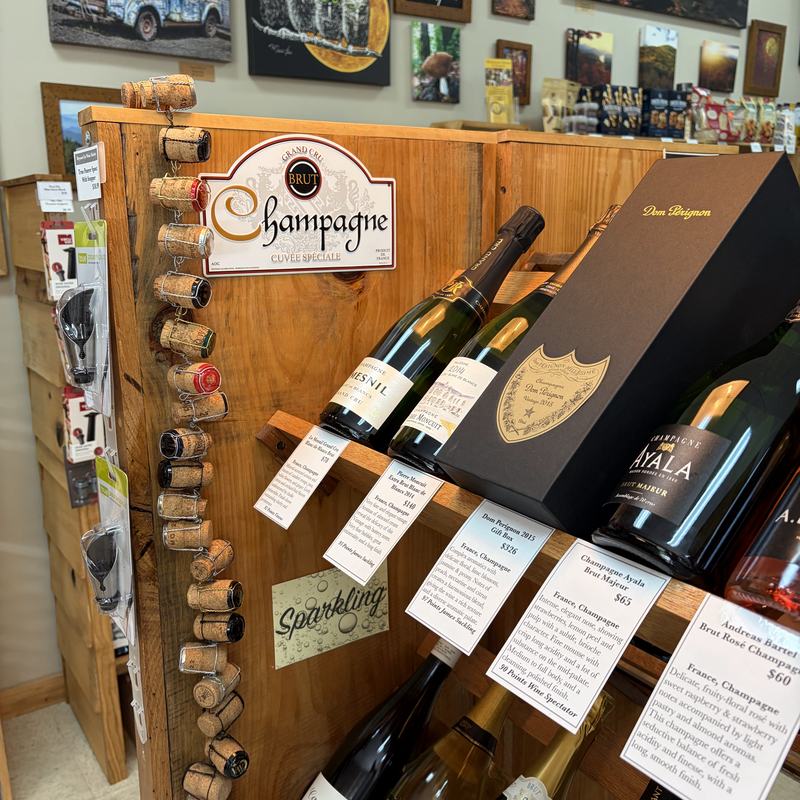 The sparkling wine display, with Champagne bottles on a wooden rack decorated with saved corks